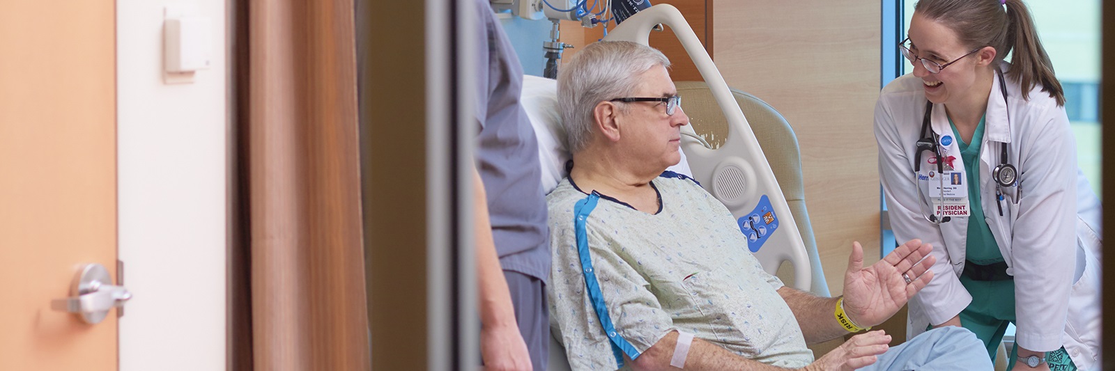 Patient sitting up in bed to talk with doctor